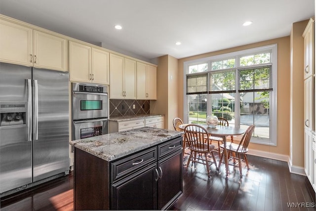 171 Harbridge Mnr, Amherst, NY 14221 - kitchen featuring appliances with stainless steel finishes, cream cabinets, light stone counters, tasteful backsplash, and recessed lighting