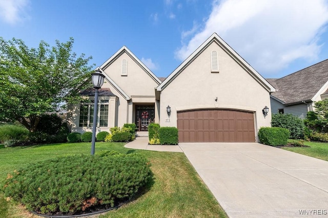 171 Harbridge Mnr, Amherst, NY 14221 - traditional-style house with stucco siding, an attached garage, a front yard, and concrete driveway