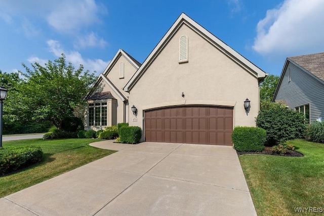 171 Harbridge Mnr, Amherst, NY 14221 - view of front facade featuring stucco siding, a front yard, driveway, and a garage