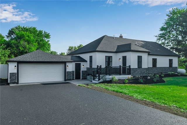 4221 Upper Mountain Rd, Cambria, NY 14132 - view of front of home with stone siding, a garage, driveway, and a front yard