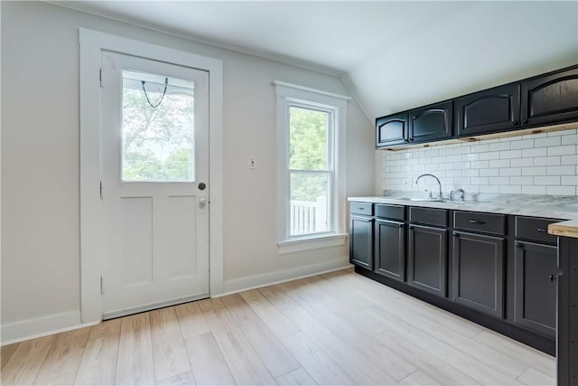 26 Fountain St, Rochester, NY 14620 - kitchen featuring light countertops, backsplash, vaulted ceiling, and light wood-style flooring