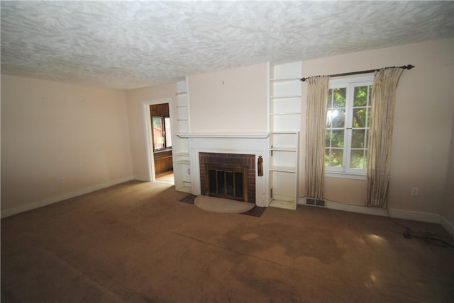 11 Elmwood Ave, Hornellsville, NY 14843 - unfurnished living room with a textured ceiling, a brick fireplace, and carpet floors