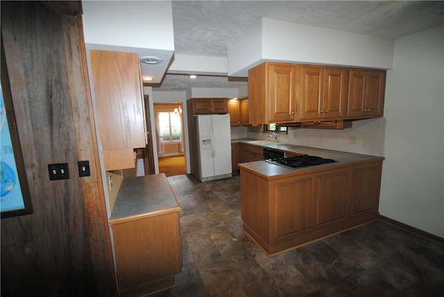11 Elmwood Ave, Hornellsville, NY 14843 - kitchen featuring white fridge with ice dispenser, brown cabinetry, gas cooktop, a peninsula, and stone finish flooring