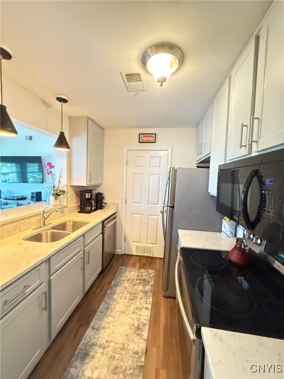 2301 Greymoor Way, Lysander, NY 13027 - kitchen featuring stainless steel appliances, dark wood finished floors, light stone countertops, and pendant lighting