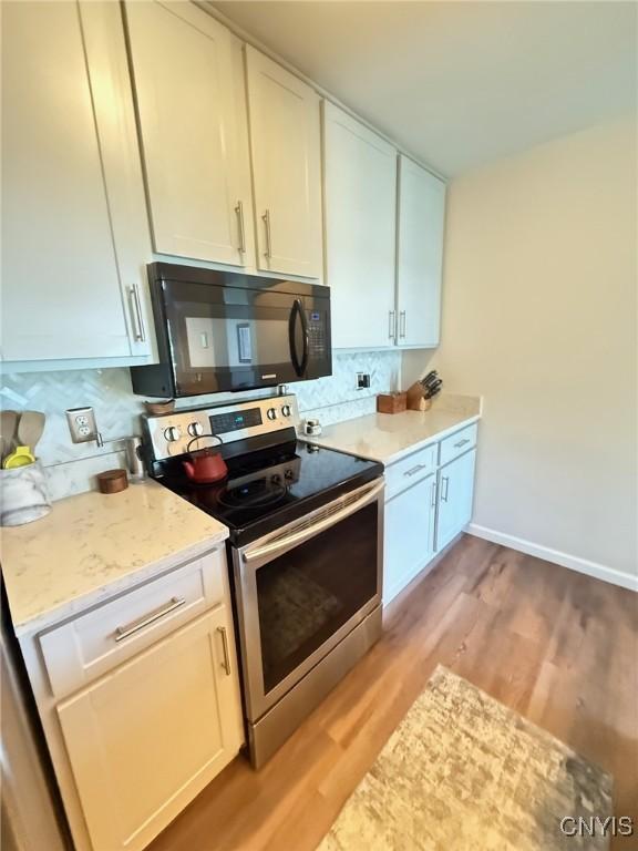 2301 Greymoor Way, Lysander, NY 13027 - kitchen featuring black microwave, stainless steel electric stove, light wood-type flooring, and tasteful backsplash