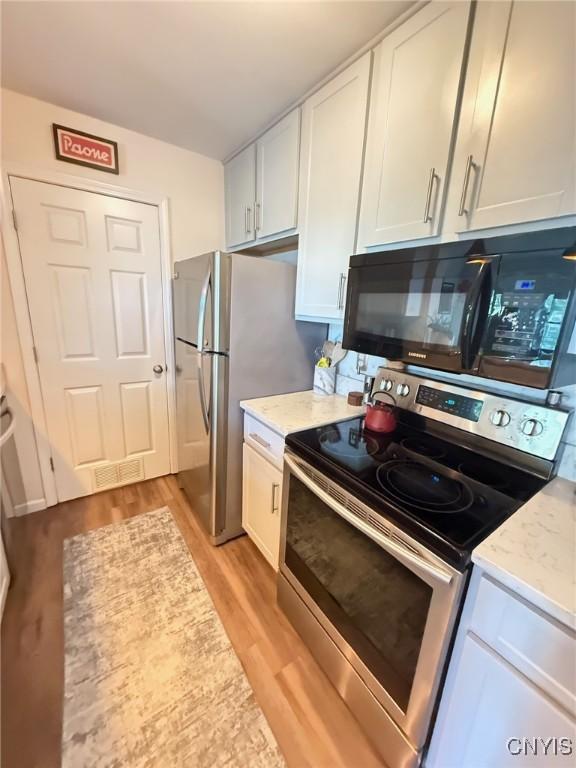 2301 Greymoor Way, Lysander, NY 13027 - kitchen featuring stainless steel appliances, light wood-style floors, white cabinetry, and light stone counters