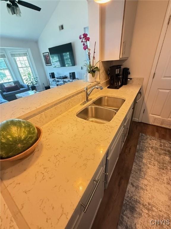 2301 Greymoor Way, Lysander, NY 13027 - kitchen featuring dark wood-style floors, light stone counters, a ceiling fan, open floor plan, and high vaulted ceiling