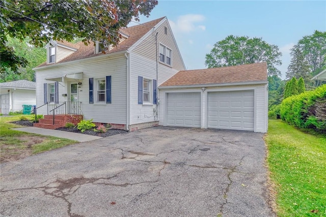 2862 Culver Rd, Irondequoit, NY 14622 - cape cod home with driveway, an attached garage, and a front lawn