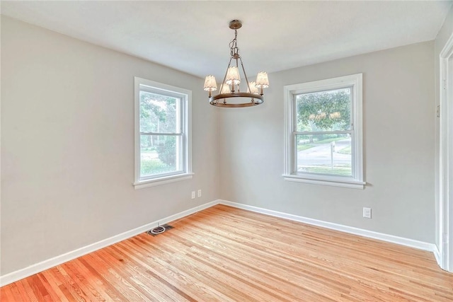 2862 Culver Rd, Irondequoit, NY 14622 - empty room with a chandelier, healthy amount of natural light, and light wood-style flooring