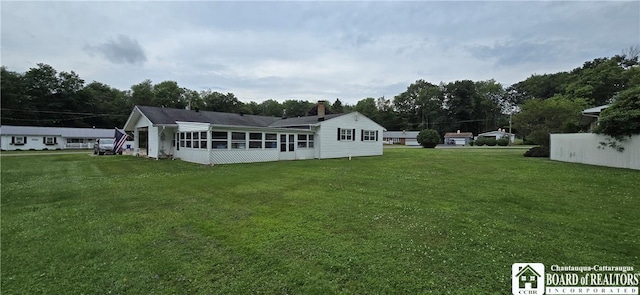 1710 Haskell Pkwy, Portville, NY 14760 - back of house featuring a lawn, a sunroom, and a chimney