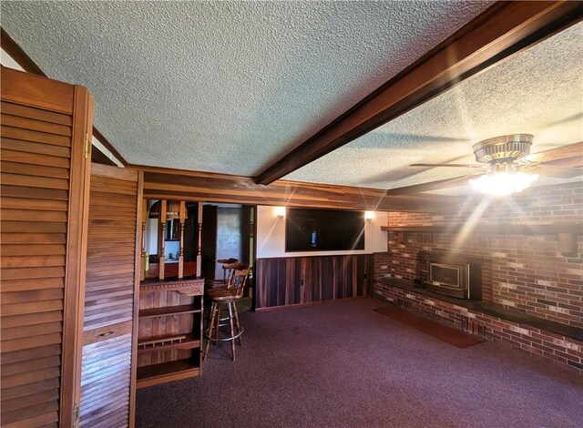 310 E Green St, Smethport Boro, PA 16749 - interior space featuring a wood stove, a textured ceiling, a ceiling fan, and wood walls