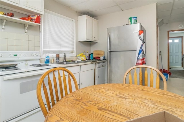 430 Ridgeway Ave, Rochester, NY 14615 - kitchen with white electric range, freestanding refrigerator, a paneled ceiling, white cabinetry, and light countertops