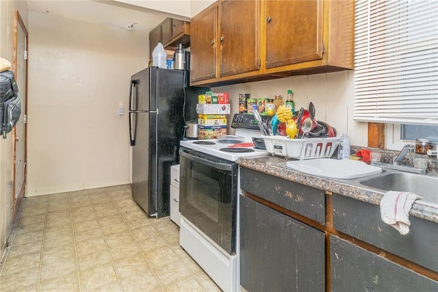 430 Ridgeway Ave, Rochester, NY 14615 - kitchen featuring white electric range oven, freestanding refrigerator, light flooring, and brown cabinetry