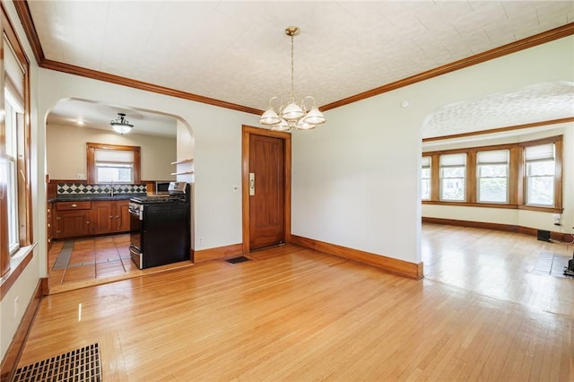 1043 Genesee Park Blvd, Rochester, NY 14619 - kitchen with stainless steel stove, arched walkways, dark countertops, light wood-type flooring, and crown molding