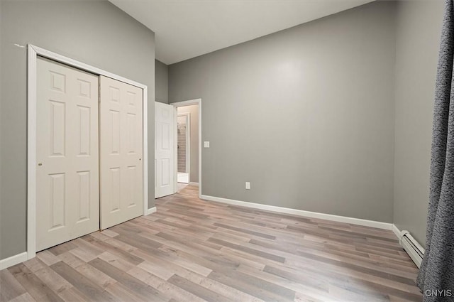 5640 Fearon Rd, Eaton, NY 13408 - unfurnished bedroom featuring a baseboard radiator, light wood-type flooring, and a closet
