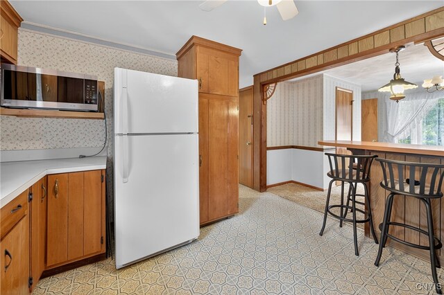 7165 Manlius Center Rd, Manlius, NY 13057 - kitchen featuring wallpapered walls, freestanding refrigerator, stainless steel microwave, light floors, and light countertops