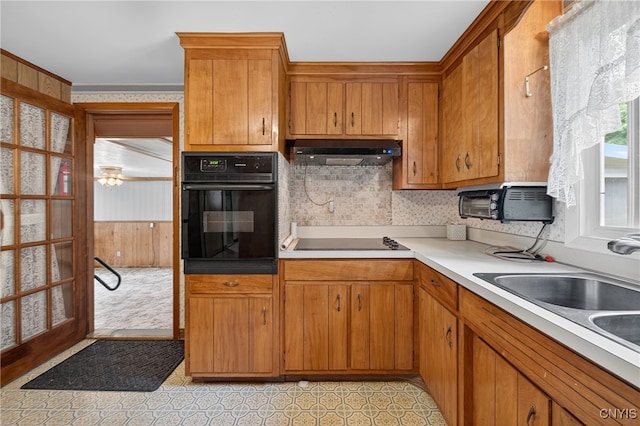 7165 Manlius Center Rd, Manlius, NY 13057 - kitchen featuring black appliances, brown cabinets, light countertops, under cabinet range hood, and tasteful backsplash