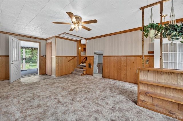 7165 Manlius Center Rd, Manlius, NY 13057 - carpeted empty room featuring stairs, ceiling fan, wood walls, and wainscoting