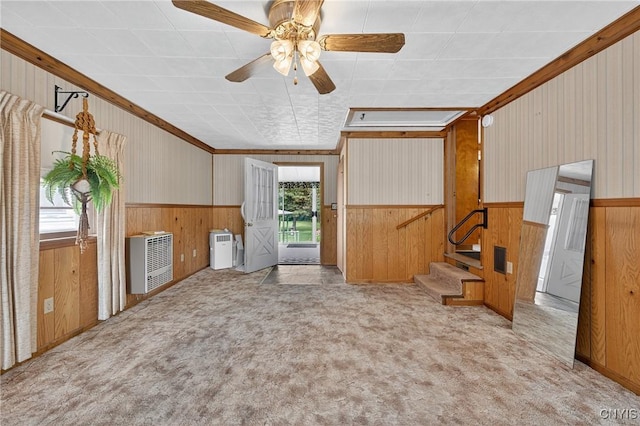 7165 Manlius Center Rd, Manlius, NY 13057 - unfurnished living room with wooden walls, carpet flooring, wainscoting, heating unit, and ceiling fan