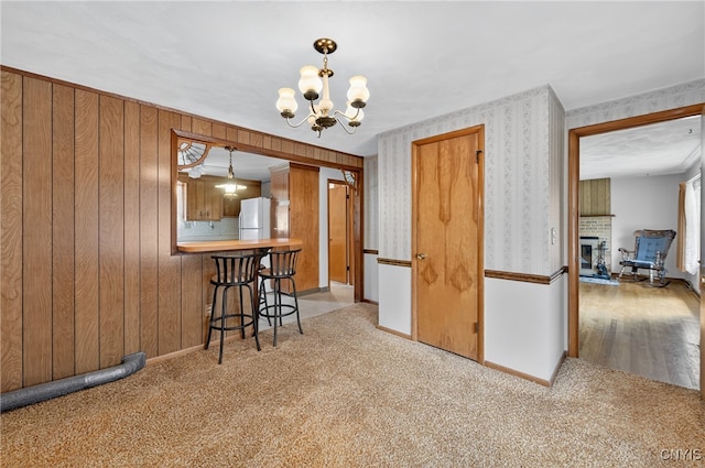 7165 Manlius Center Rd, Manlius, NY 13057 - carpeted dining room featuring a chandelier, wallpapered walls, and wooden walls