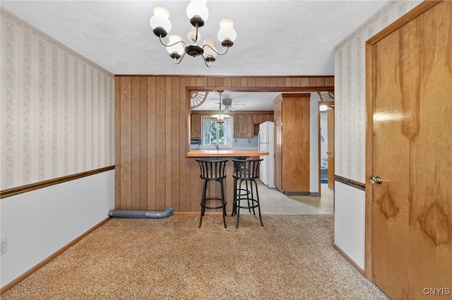 7165 Manlius Center Rd, Manlius, NY 13057 - dining space featuring a chandelier, light carpet, wallpapered walls, and a ceiling fan