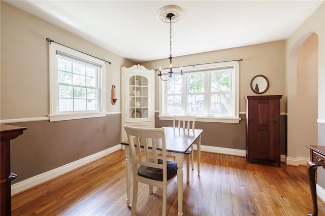36 Dover Park, Brighton, NY 14610 - dining room featuring arched walkways, light wood-type flooring, and a chandelier