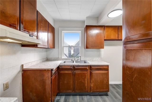 386 Davey St, Buffalo, NY 14206 - kitchen with dark wood-style flooring, light countertops, under cabinet range hood, and brown cabinets