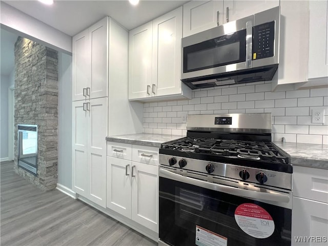155 Barnsdale Ave, West Seneca, NY 14224 - kitchen featuring appliances with stainless steel finishes, white cabinetry, decorative backsplash, and light wood-style flooring