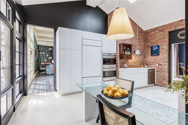 3399 Elmwood Ave, Brighton, NY 14610 - kitchen with high vaulted ceiling, modern cabinets, stainless steel appliances, white cabinets, and brick wall