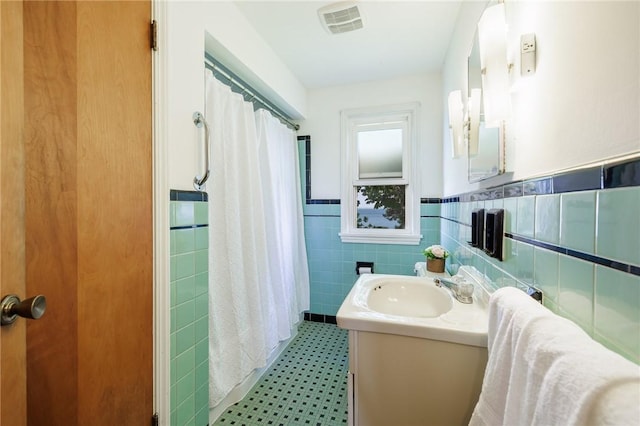 760 Beach Ave, Rochester, NY 14612 - full bath featuring tile walls, vanity, a shower with shower curtain, a wainscoted wall, and tile patterned floors