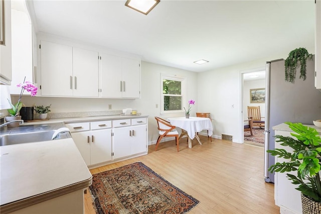 760 Beach Ave, Rochester, NY 14612 - kitchen with light countertops, light wood-type flooring, and white cabinetry