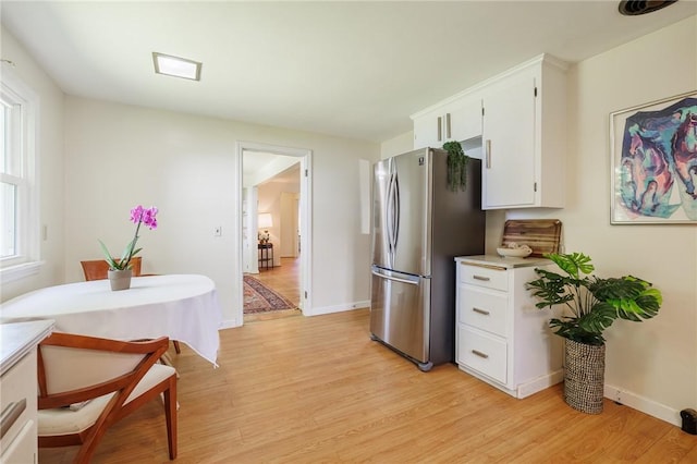 760 Beach Ave, Rochester, NY 14612 - kitchen with light wood-style flooring, freestanding refrigerator, white cabinetry, and light countertops