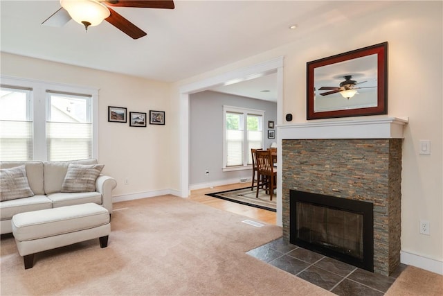 121 Reynolds Ave, Corning City, NY 14830 - living room featuring a ceiling fan, a stone fireplace, and carpet floors