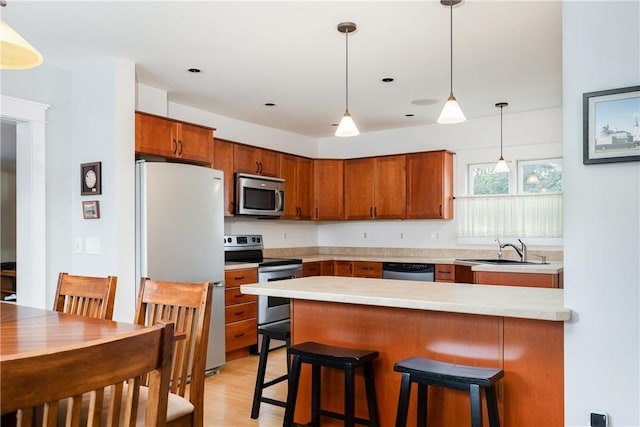 121 Reynolds Ave, Corning City, NY 14830 - kitchen with stainless steel appliances, light countertops, a peninsula, pendant lighting, and brown cabinetry