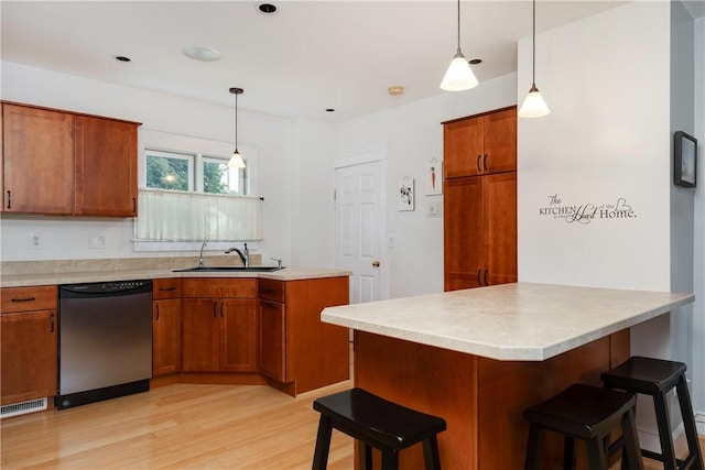 121 Reynolds Ave, Corning City, NY 14830 - kitchen with a peninsula, a kitchen bar, dishwasher, brown cabinets, and light wood-style flooring