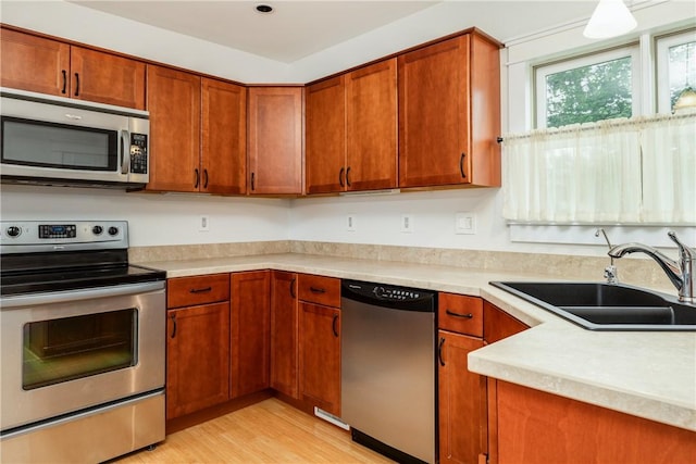 121 Reynolds Ave, Corning City, NY 14830 - kitchen featuring stainless steel appliances, light wood finished floors, light countertops, and brown cabinets