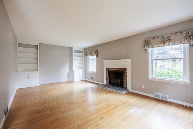 360 San Gabriel Dr, Rochester, NY 14610 - unfurnished living room featuring light wood-style flooring, a fireplace, and built in features