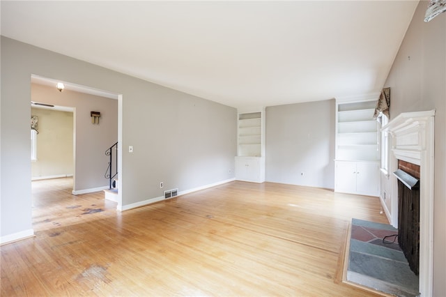 360 San Gabriel Dr, Rochester, NY 14610 - unfurnished living room featuring a fireplace, built in features, and light wood-type flooring