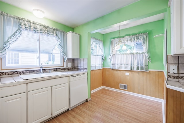360 San Gabriel Dr, Rochester, NY 14610 - kitchen with wainscoting, light wood-style flooring, white cabinets, healthy amount of natural light, and white dishwasher