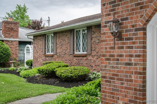 573 Locust St, North Tonawanda, NY 14120 - view of side of home featuring brick siding, a shingled roof, and a chimney