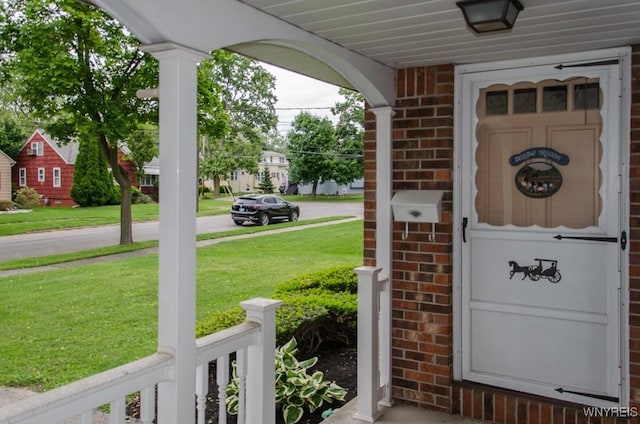 573 Locust St, North Tonawanda, NY 14120 - property entrance featuring brick siding, a yard, and a porch