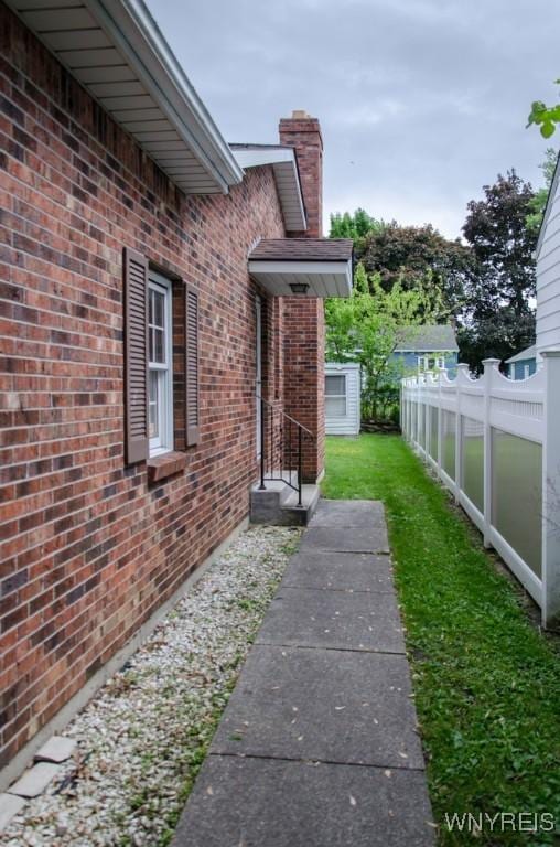 573 Locust St, North Tonawanda, NY 14120 - view of property exterior featuring brick siding and a chimney