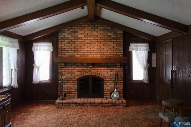 573 Locust St, North Tonawanda, NY 14120 - unfurnished living room featuring wooden walls, a fireplace, healthy amount of natural light, a textured ceiling, and carpet flooring