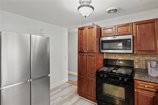 111 Crimson Bramble Rd, Henrietta, NY 14623 - kitchen featuring appliances with stainless steel finishes, light wood-type flooring, decorative backsplash, dark stone counters, and brown cabinets