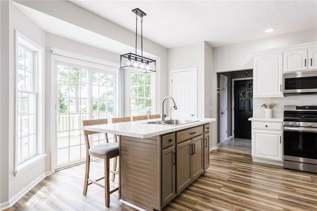 2023 Rainbow Ln, Lima, NY 14485 - kitchen with appliances with stainless steel finishes, light wood-type flooring, light countertops, white cabinets, and decorative backsplash