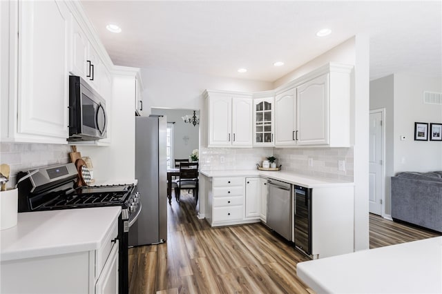 2023 Rainbow Ln, Lima, NY 14485 - kitchen with stainless steel appliances, light wood-style flooring, white cabinets, tasteful backsplash, and beverage cooler