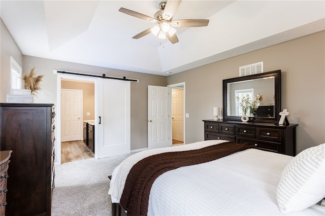 2023 Rainbow Ln, Lima, NY 14485 - bedroom with a barn door, light carpet, ceiling fan, a raised ceiling, and vaulted ceiling