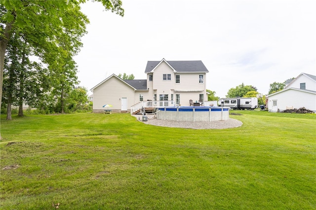 2023 Rainbow Ln, Lima, NY 14485 - back of property with an outdoor pool, a lawn, and a wooden deck