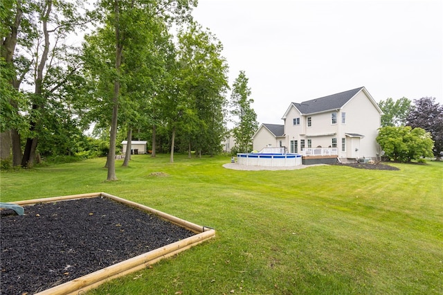 2023 Rainbow Ln, Lima, NY 14485 - view of grassy yard with an outdoor pool and a wooden deck