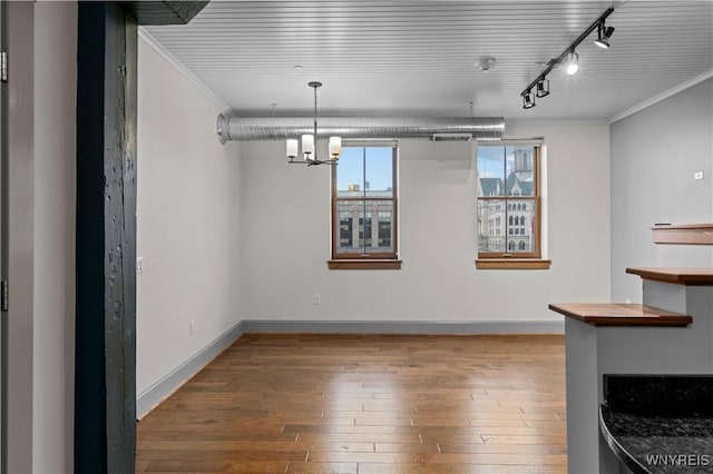 149 Swan St Unit 310, Buffalo, NY 14203 - unfurnished dining area with hardwood / wood-style floors, crown molding, track lighting, and a chandelier